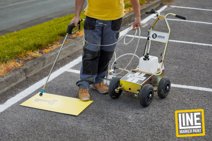A line marking machine markings a car park bay. When Should You Repaint Road Markings?