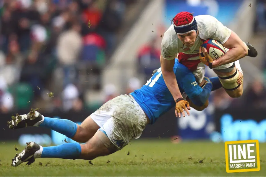 An action shot of a mid-air rugby tackle. The Dimensions Of A Rugby Pitch